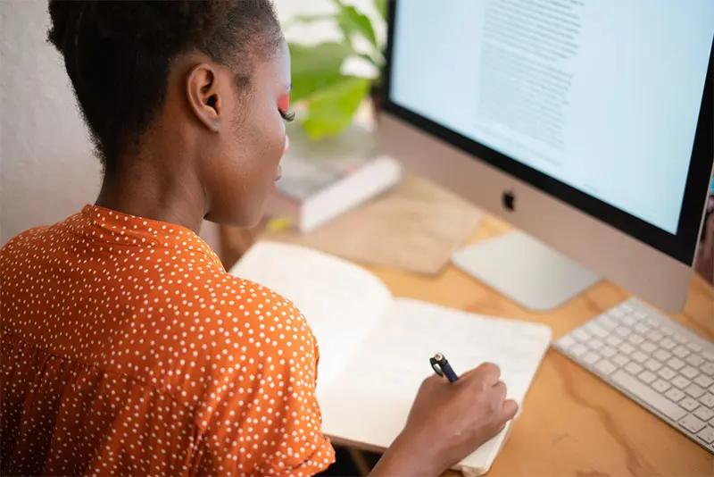 woman working from home taking notes