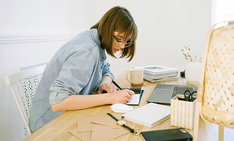 woman writing at desk